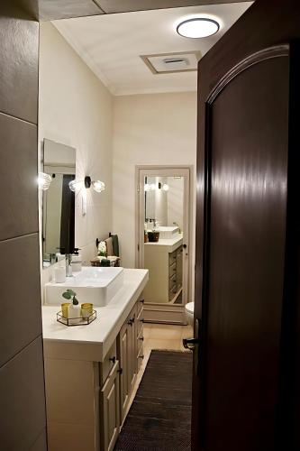 a bathroom with a white sink and a mirror at A Casa dos Raminhos in Vila de Frades