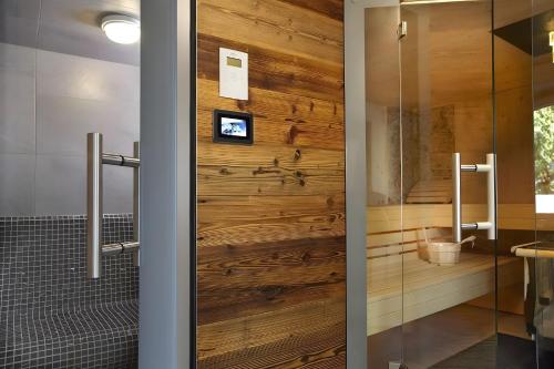 a pivot door in a bathroom with a wooden wall at Chillout in Ibach