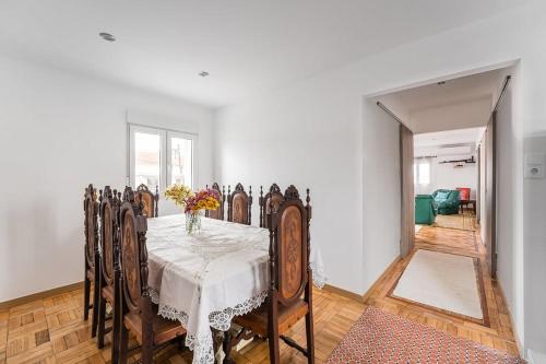 a dining room with a table with a vase of flowers on it at Moradia Aura Santi in Esposende