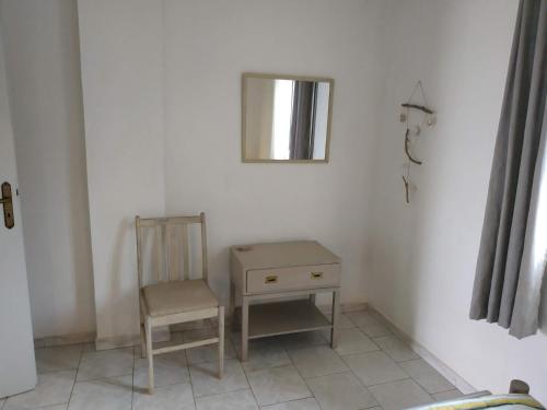 a chair and a table and a mirror in a room at Perasma Studios 11 in Kipri