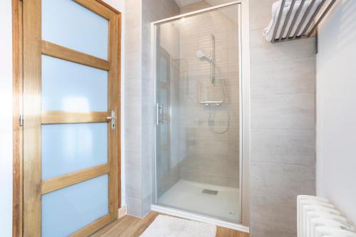 a bathroom with a shower with a glass door at Ce Petit Penty in Douarnenez
