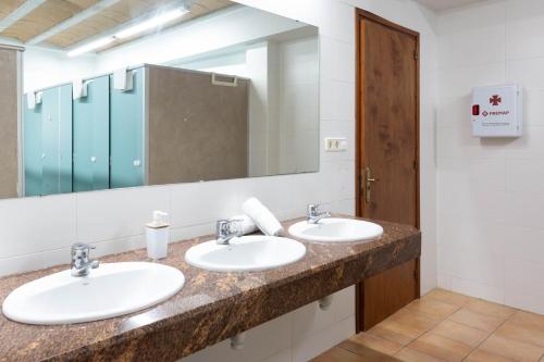 a bathroom with two sinks and a large mirror at Mas Tortós in Palafolls