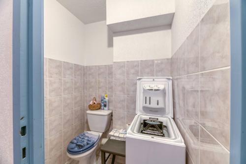 a small bathroom with a washer and dryer next to a toilet at Chalet de l'Ardoisière in Saint-Colomban-des-Villards
