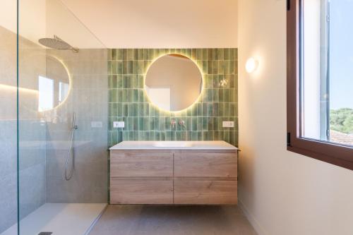a bathroom with a sink and a shower with a mirror at Villa Lorena in Islas Baleares