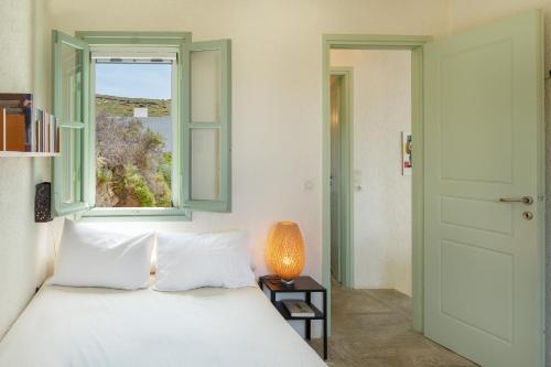 a bedroom with a white bed and a window at Casa Xyla-sunset view villa in Melissaki