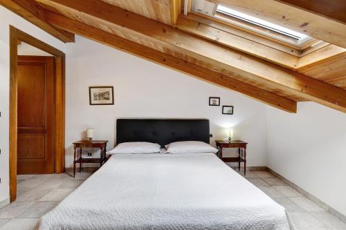 a bedroom with a large bed with wooden ceilings at Maison Noris in Finale Ligure