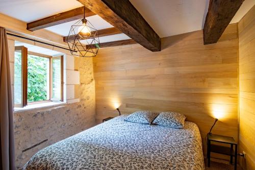a bedroom with a bed in a room with wooden walls at Gite des Bois du Charme in Chalais