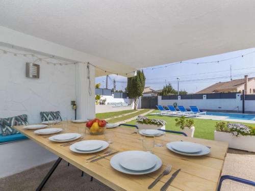 a wooden table with plates and silverware on it at Villa Mi Capricho by Interhome in Calafell