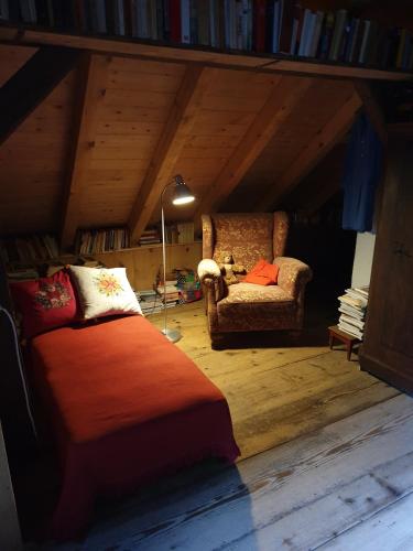 a bedroom with a bed and a chair in a attic at Historisches Bahnwärterhaus in Gremmelsbach