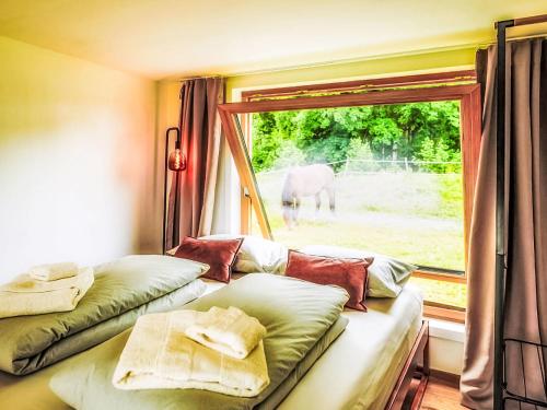 a room with two beds and a window with an elephant outside at Chalet Boutique Tiny House by Interhome in Rothenthurm