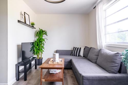 a living room with a gray couch and a table at Jungle House Modern Lofts - Arena District & Short North in Columbus