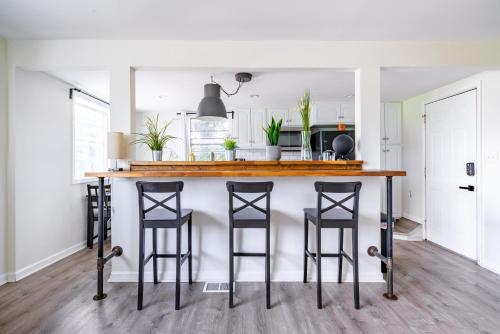 a kitchen with a counter with four bar stools at Jungle House Modern Lofts - Arena District & Short North in Columbus