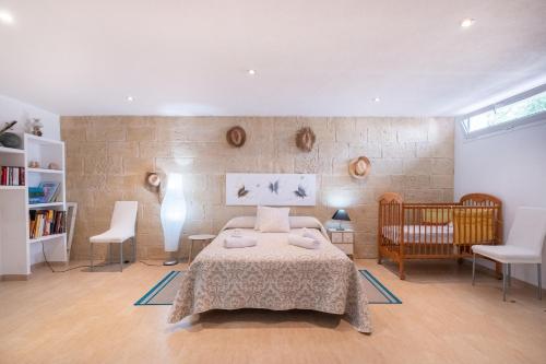 a bedroom with a bed and a crib and chairs at Abatzer in Ciutadella
