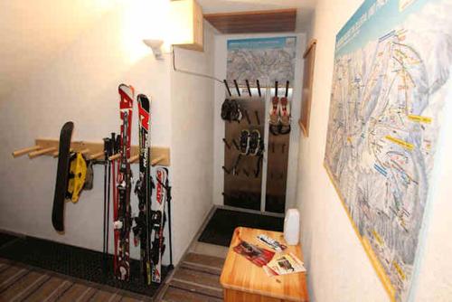 a room with skis hanging on a wall and a refrigerator at Ferienwohnungen Flörl in Zell am Ziller