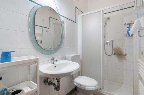 a bathroom with a sink and a toilet and a mirror at Coral House Viareggio in Viareggio