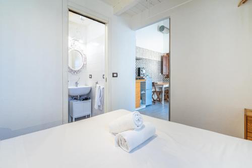 a white bedroom with a white bed and a bathroom at Casamari nel centro di Marzamemi in Marzamemi