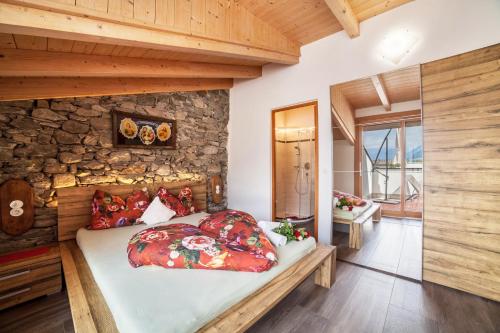 a bed in a room with a stone wall at Sagschneiderhof Red Delicious in Plaus