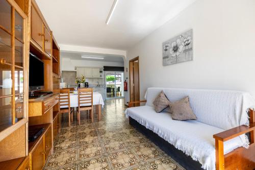 a living room with a white couch and a kitchen at Villas Brites nº5 in Burgau