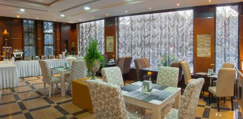 a restaurant with tables and chairs and a bar at Al Farhan Suites Ishbillia in Riyadh