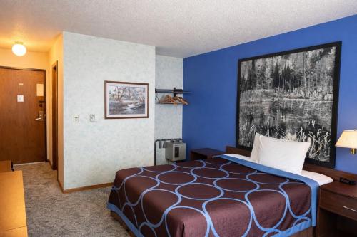 a bedroom with a bed in a room with blue walls at Iron Mountain Inn & Suites MI US 2 in Iron Mountain