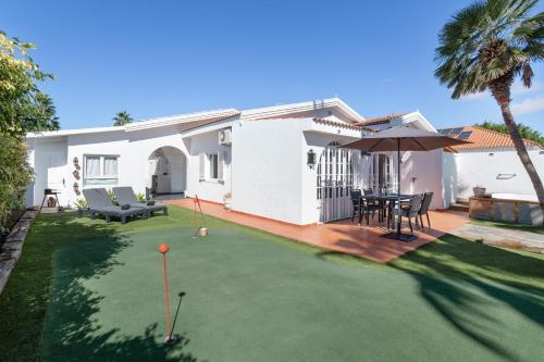 a yard with a putting green and a house at Exclusive Villa with Heated Pool in Maspalomas