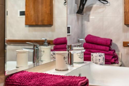 a bathroom with red towels and a sink with a mirror at Lo Sondzo in Nus