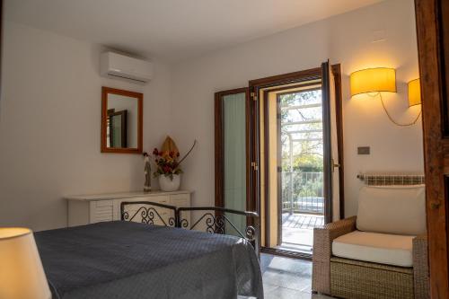 a bedroom with a bed and a chair and a window at I Profumi Dell'Orto - Campagnatico in Campagnatico