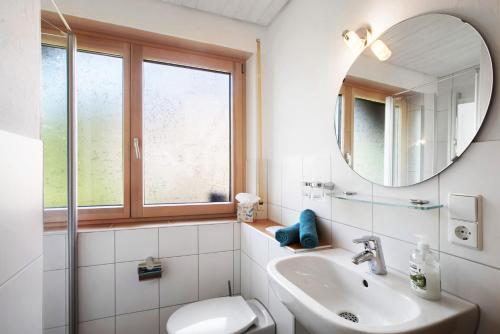 a white bathroom with a sink and a mirror at Gästehaus Hanni in Todtmoos
