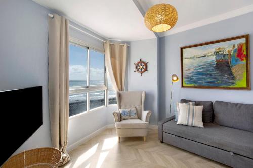 a living room with a couch and a window at Ocean Side Arinaga in Arinaga
