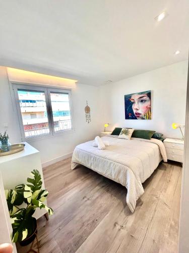 a bedroom with a large bed and two windows at Sueña Mar Luxury Suites in Torrevieja