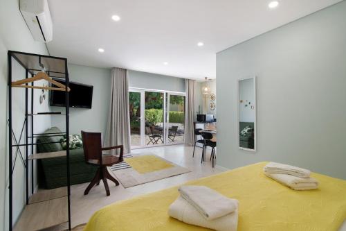ein Schlafzimmer mit einem gelben Bett und ein Wohnzimmer in der Unterkunft Excelente Studio in Loulé