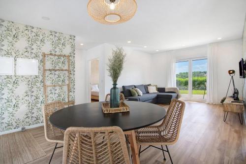 a living room with a table and chairs and a couch at Casa da Vinha in Óbidos
