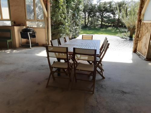 a wooden table and chairs in a patio at La Grange De Vauviault in Bressuire