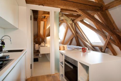 a kitchen with white counters and wooden ceilings at Schloss Kirchberg - Schlossnest in Immenstaad am Bodensee