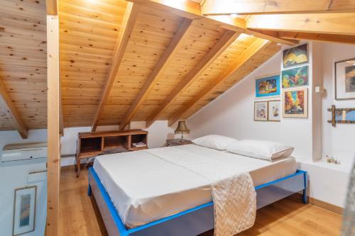 a bedroom with a bed and wooden ceilings at Zoe apartment in Marantochori