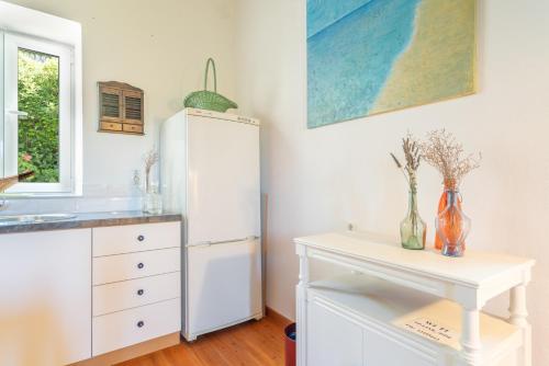 a kitchen with a white refrigerator and a table at Zoe apartment in Marantochori