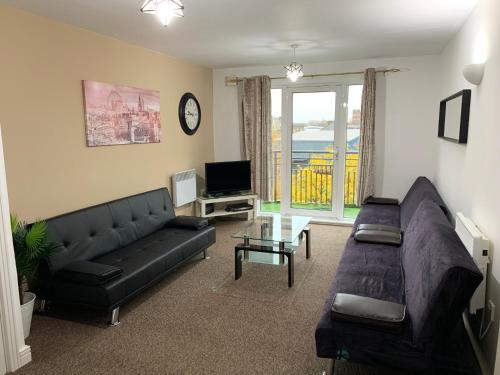 a living room with a couch and a tv at 2 Bedrooms Modern Apartment, Lounge, Full Kitchen, Balcony, 5 minutes Stratford Station in London