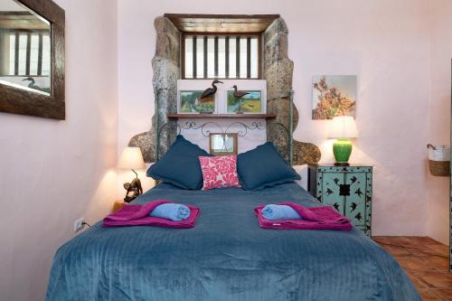 a bedroom with a blue bed with two pillows at El Cello in Mácher