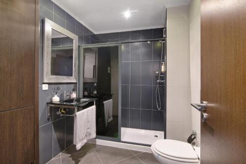a bathroom with a shower with a toilet and a sink at Apartamento Freire in Portimão