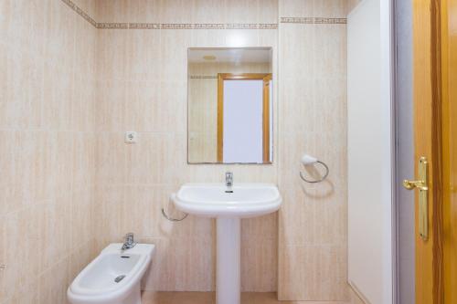 a bathroom with a sink and a mirror and a toilet at Carmen in Oliva