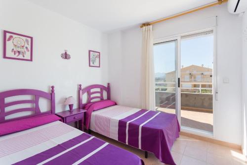 a bedroom with two beds and a large window at Carmen in Oliva