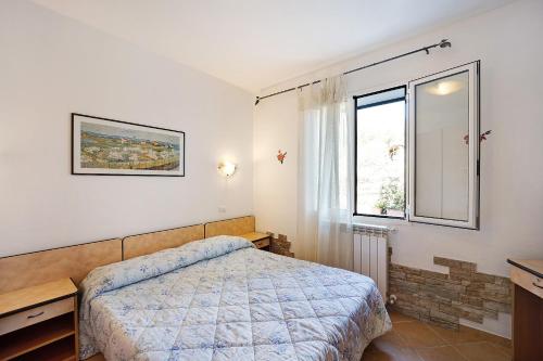 a bedroom with a bed and a window at Le Mimose Bilo4 bis in Imperia