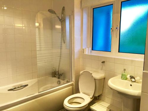 a white bathroom with a toilet and a sink at 2 Bedrooms Modern Apartment, Lounge, Full Kitchen, Balcony, 5 minutes Stratford Station in London