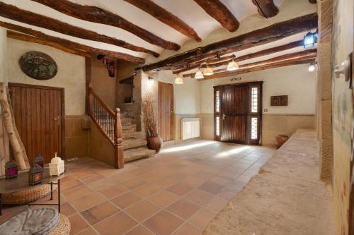 a large hallway with wooden ceilings and a staircase in a building at Atalaya in Santa Eulalia la Mayor