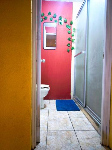 a bathroom with a red door and a toilet at Casa Mary's in Quetzaltenango