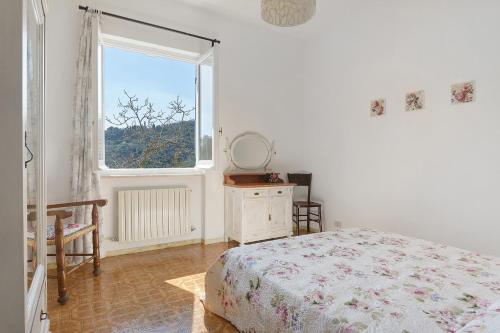 a white bedroom with a bed and a window at Il Noce - vicino Chiavari in Leivi