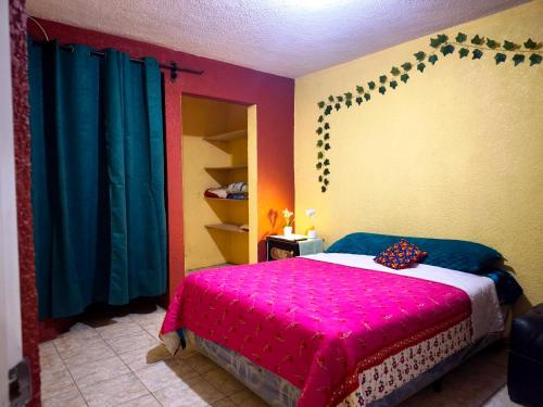 a bedroom with a bed with a pink blanket at Casa Mary's in Quetzaltenango