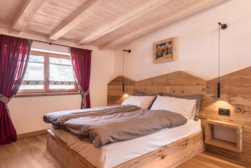 a bedroom with a large bed with a wooden headboard at Majon Baticher in Canazei