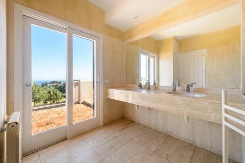 a bathroom with two sinks and a large window at Can Roca in Illes Balears