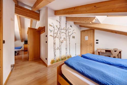 a bedroom with a bed with blue sheets on it at Residence Montebel Studio in Tesero